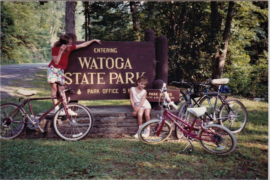 These two sisters with their bicycles pose at the Watoga State Park entrance sign. Sisters Rachelle (L) and Sara (R) had more than one Top 10 List when visiting Watoga as a family each year as part of the Bott family.  📸: David Bott, 1987.