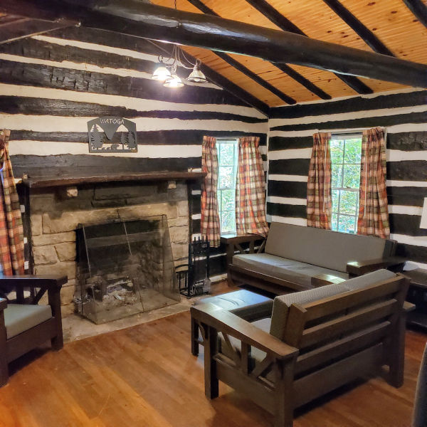 Interior of a Legacy Cabin (Cabin No. 11) highlights new furniture and interior upgrades. A fireplace takes center state as does the wood work and hewn logs from the 1930s.Photo by John Dean.