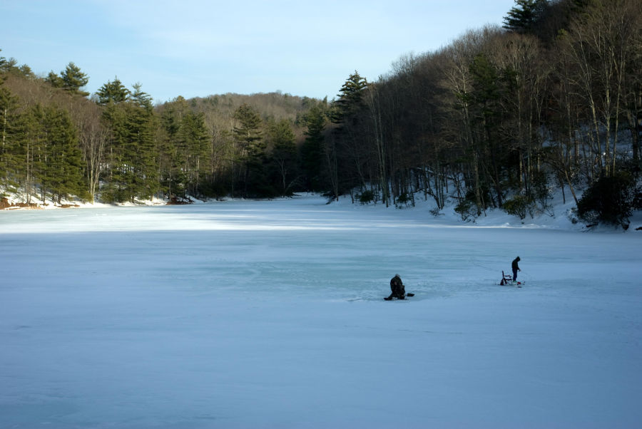 The morning sunshine peeks across the frozen Watoga Lake. Ice anglers cast a line or two to try to catch a fish on this frigid winter day. Ice fishing enthusiasts enjoy a winter day at 11-acre Watoga Lake. Photo by Stanley Clark©