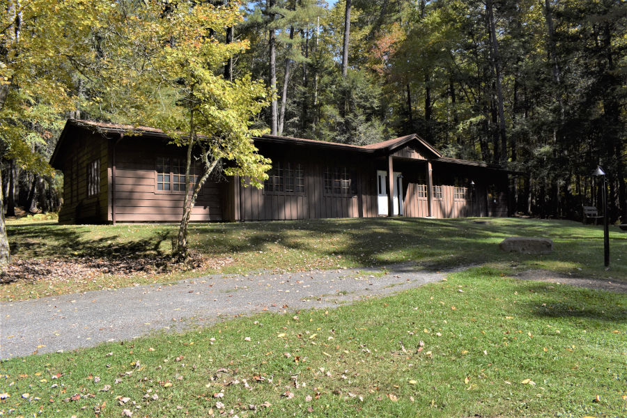 The brown sided wood building at 2,100 square feet is atop a hill not far from the swimming pool. This is a photo in the early fall of 2020.