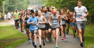 A group of runners leave the finish line at the Mountain Tral Challenge 5K races at Watoga State Park